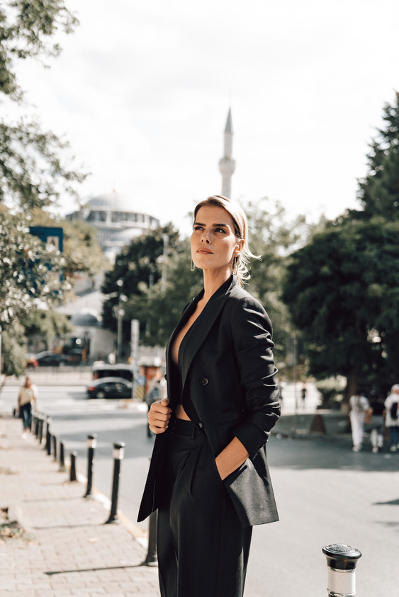 Elegant woman in formal suit standing on sidewalk